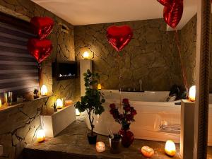 a bathroom with red heart balloons and a tub at Trzy Kopce 