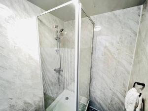 um chuveiro com uma porta de vidro na casa de banho em Spacious Retreat: 8BR House in Prime Location em Liverpool