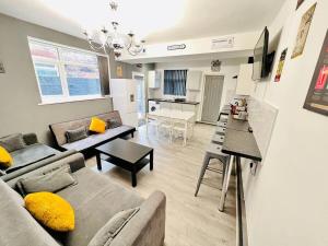 uma sala de estar com um sofá e uma mesa em Spacious Retreat: 8BR House in Prime Location em Liverpool