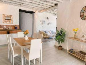 een eetkamer en een woonkamer met een tafel en stoelen bij La Palmera. Casa rural con piscina privada. in Benadalid