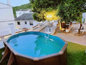 a large swimming pool in a yard with a house at La Palmera. Casa rural con piscina privada. in Benadalid