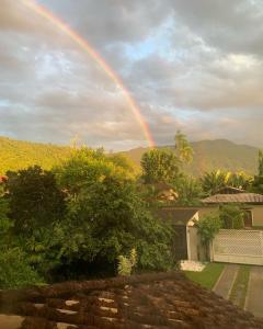 a rainbow in the sky over a house at Pousada Luamar in Paraty