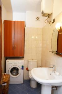 ein Badezimmer mit einem WC, einem Waschbecken und einer Waschmaschine in der Unterkunft New Bazaar Bliss in Tirana