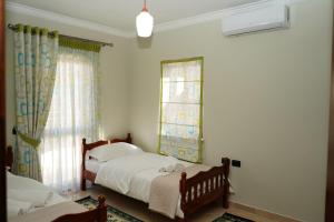 2 Betten in einem Zimmer mit 2 Fenstern in der Unterkunft New Bazaar Bliss in Tirana