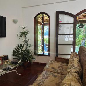 - un salon avec un canapé et 2 fenêtres dans l'établissement Hostel 040, à Itaipava