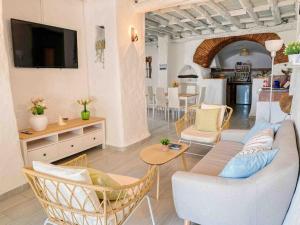 uma sala de estar com um sofá, cadeiras e uma mesa em La Palmera. Casa rural con piscina privada. em Benadalid