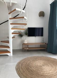 a living room with a spiral staircase and a tv at Al_andalus_404 in Alcossebre