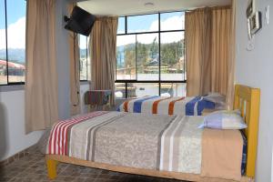 a bedroom with two beds and a large window at Makalu Lodge in Huaraz