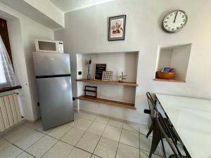 a kitchen with a refrigerator and a clock on the wall at Appartamento Nido Del Lago in Lenno