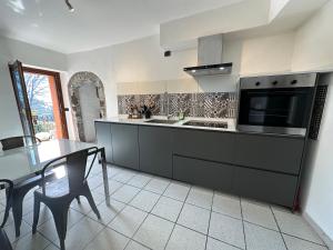 a kitchen with a sink and a stove top oven at Appartamento Nido Del Lago in Lenno