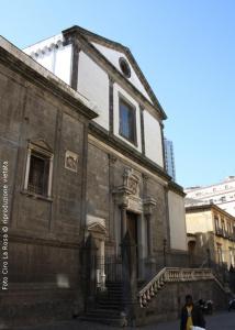 un antiguo edificio con una persona caminando delante de él en Spazio, en Nápoles