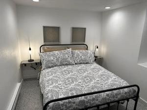 a bedroom with a bed and a table with two lamps at Basement Bliss: Cozy Getaway in Cheyenne
