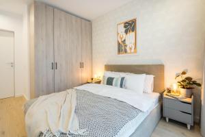 ブカレストにあるBOTANlQUE 1BR in Business Centreのベッドルーム(白い大型ベッド1台、キャビネット付)