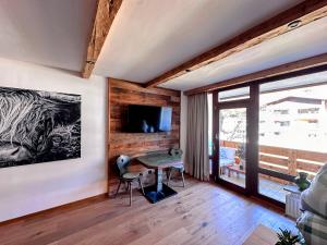 a room with a table and chairs and a television at Grubhof Schlosspark, Chalet-Stil mit Pool und Bergblick - Air Conditioner in Sankt Martin bei Lofer