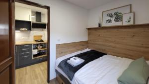 a small bedroom with a bed with a wooden headboard at HIŠKA TIBAUT 122 vključene kopalne karte in Veržej