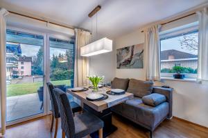 a living room with a dining room table and a couch at Well-Home Apartments Velden Top1 in Velden am Wörthersee