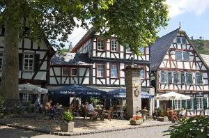 a building with people sitting at tables in front of it at Studio-Loft Siebengebirge Westerwald in Erpel