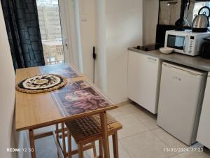 een kleine keuken met een tafel en een magnetron bij Un nid sur les toits avec terrasse in Apt
