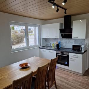 een keuken met een houten tafel en een tafel en stoelen bij Apartment da Luiz Salvatore in Wurmlingen