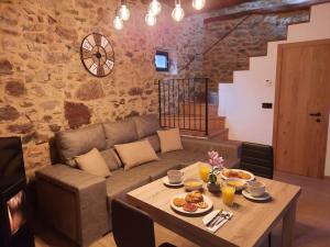 sala de estar con sofá y mesa con comida en El Regueron, en Folgoso de la Ribera