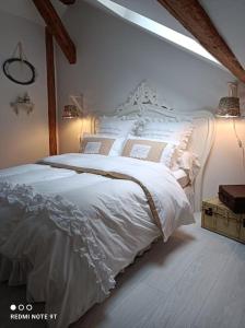 ein Schlafzimmer mit einem weißen Bett in einem Zimmer in der Unterkunft Loft atypique de charme, garage privatif in Barr