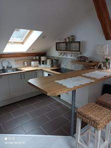 eine Küche mit einem Tisch, einem Waschbecken und einem Fenster in der Unterkunft Loft atypique de charme, garage privatif in Barr