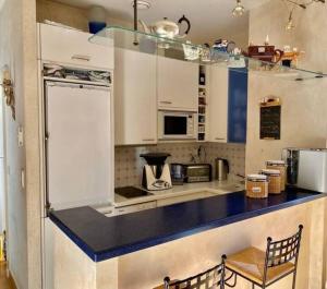 a kitchen with white cabinets and a blue counter top at 2 pièces au centre de Monaco in Monte Carlo