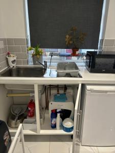 a kitchen counter top with a sink and a kitchenilit at Tranquil Escape in Tilehurst