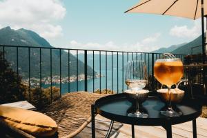 una mesa con 2 vasos en la parte superior de un balcón en B&B Villa le Ortensie, en Faggeto Lario 