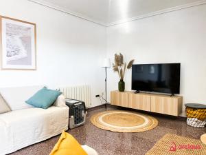 salon z telewizorem i kanapą w obiekcie La Villa w mieście Benicàssim