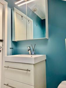 a bathroom with a white sink and a mirror at Villa by the sea, close to the city, with panoramic views in Bergen