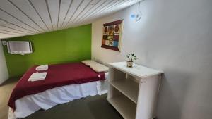 Habitación pequeña con cama y mesa pequeña. en Pousada Mojomar Buzios, en Búzios