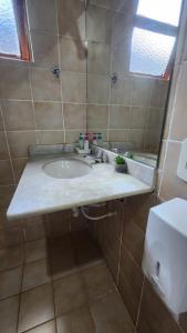 a bathroom with a sink and a mirror at Pousada Mojomar Buzios in Búzios