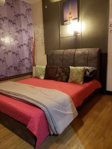 a bedroom with a large bed with a red blanket at The Mons inside Tower Regency Hotel and Apartments in Ipoh