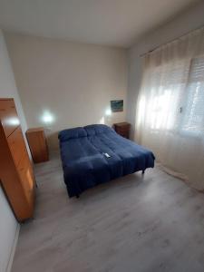 um quarto com uma cama azul e uma janela em Carpe Diem em Treviso