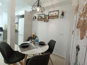 una mesa y sillas en una habitación con cocina en MalvaLindaBeach Loft Benlliure Malvarrosa/Patacona, en Valencia