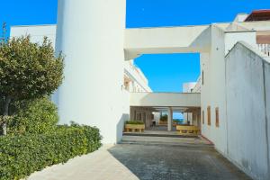 an external view of a white building with two benches at Sea view house in Otranto 4 places in Otranto