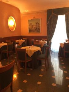 uma sala de jantar com mesas e cadeiras e uma janela em Hotel Positano Suite em Roma
