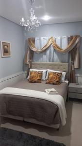 ポルト・アレグレにあるHotel Palaceのベッドルーム1室(大型ベッド1台、シャンデリア付)