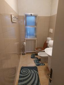 a bathroom with a toilet and a sink and a window at Carpe Diem in Treviso