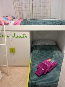 ベルレガートにあるUn Rincon en el Marの二段ベッド(緑とピンクのタオル付)