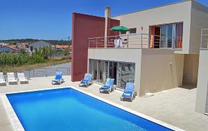 a villa with a swimming pool and blue chairs at Foz Ocean Retreat in Foz do Arelho