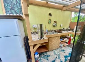 a kitchen with a sink and a refrigerator at Artsy Cabin on Organic Farm in Naalehu