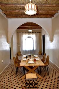uma sala de jantar com uma mesa de madeira e cadeiras em Villa sur Colline son vis-à-vis em Marrakech