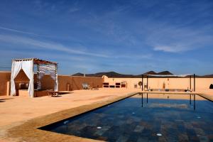 uma piscina no meio de um deserto com uma tenda em Villa sur Colline son vis-à-vis em Marrakech