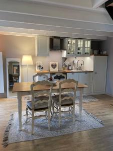 a kitchen with a wooden table and two chairs at les gites du grand saule in Tardinghen