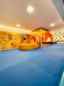 a room with a blue dance floor with a yellow couch at Napoles 2BR Zona 10 Luxury Suite - AC, Pool, Gym & View in Guatemala