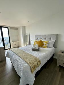 um quarto com uma grande cama branca com almofadas amarelas em Apartamento 2 Habitaciones, Edificio Airali, Zona 10, Napoles em Guatemala
