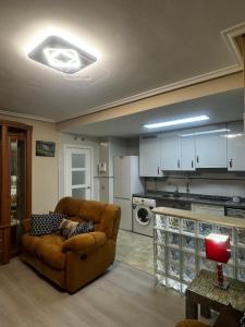 een woonkamer met een bank en een keuken bij BlueMedina Lugones in Lugones