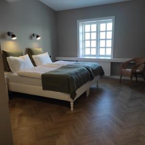 1 dormitorio con 1 cama grande y ventana en Hotel Stafholt, en Borgarnes